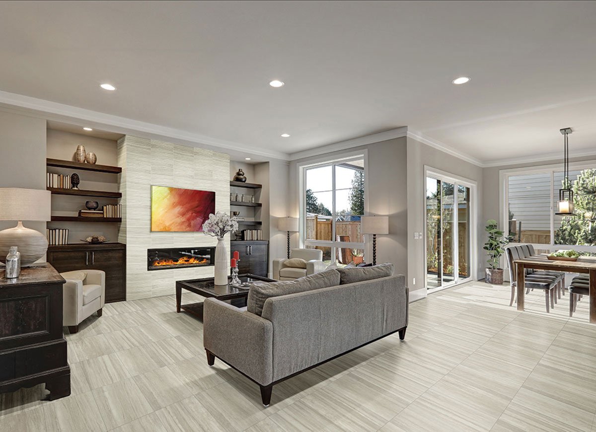 Light-colored flooring through an open living room and kitchen with a gray sectional sofa