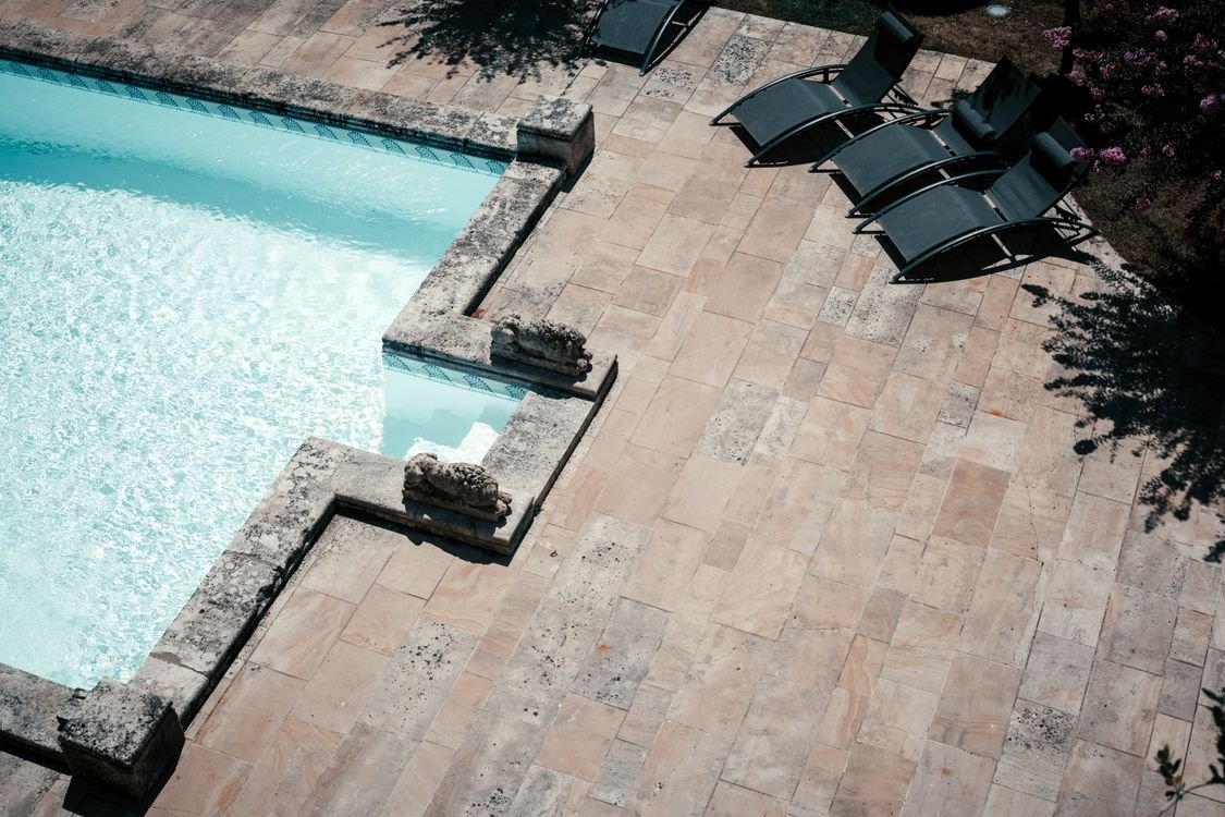 Illustrative stone-tiled terrace beside a swimming pool